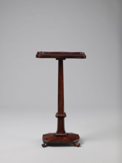 Pedestal table with a rectangular top with a wavy-cut edge and a low wooden gallery, supported by