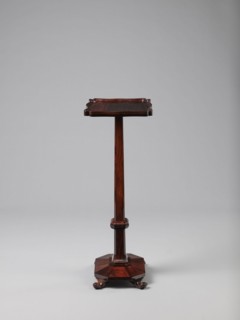 Pedestal table with a rectangular top with a wavy-cut edge and a low wooden gallery, supported by