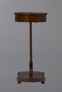 Oval display table with a lyre-shaped base mounted on a platform with a concave-convex outline,