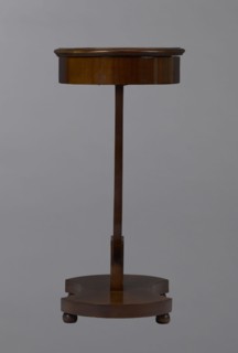 Oval display table with a lyre-shaped base mounted on a platform with a concave-convex outline,