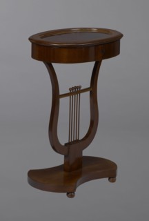 Oval display table with lyre-shaped base mounted on a platform with a concave-convex outline,