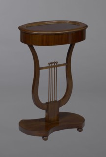 Oval display table with a lyre-shaped base mounted on a platform with a concave-convex outline,