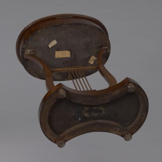 Oval display table with a lyre-shaped base mounted on a platform with a concave-convex outline,