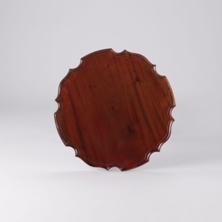 Side table with round top and wavy profiled rim, supported by a shaft of three slender turned