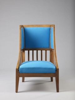 Armchair Berzera with a slender backrest and sides equal in height that arch upwards to form ears;