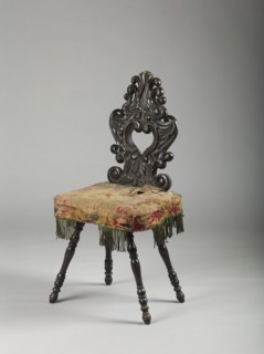 Stool with board seat, cushion attached, and openwork carved backrest; supported by four baluster