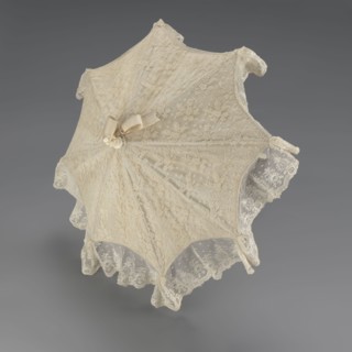 Women's umbrella made of white lace. Its canopy is trimmed with cream silk at the bottom, which