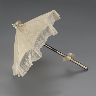 Women's umbrella made of white lace. Its canopy is trimmed with cream silk at the bottom, which