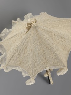 Umbrella. Women's umbrella made of white lace with a canopy trimmed with cream silk at the bottom