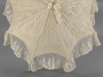 Women's umbrella made of white lace. Its canopy is trimmed with cream silk at the bottom, which