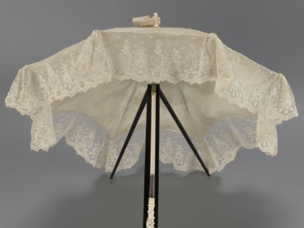 Women's umbrella made of white lace. Its canopy is trimmed with cream silk at the bottom, which