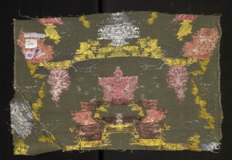 Fragment of fabric, silk, patterned with floral motifs. Pattern with a symmetrical composition of