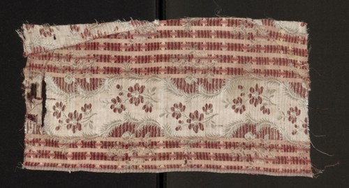 Fabric fragment, silk, patterned with floral motifs. Main motif: a wide, winding white satin ribbon