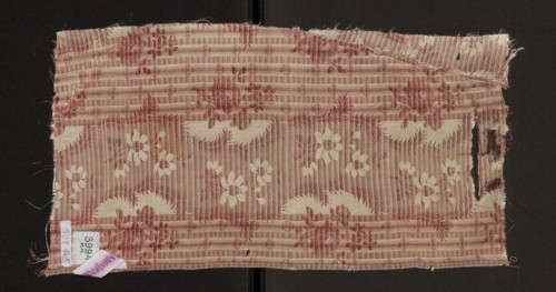 Fabric fragment, silk, patterned floral design. Main motif: wide, winding white satin ribbon with