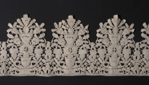 Lace fragment, Floral ornaments. Lace, lower edge serrated. In each oval there is a vase of