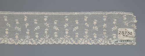 Fragment of lace, one-sided strip of edge ornament made of plant forms with a motif of a pinnately