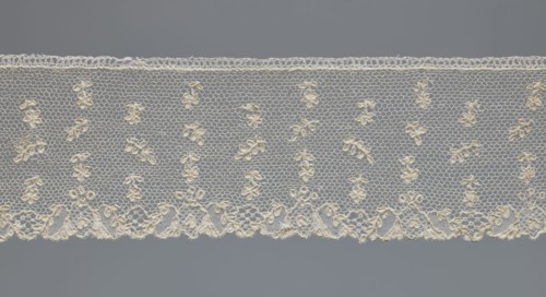 Fragment of lace, one-sided strip of edge ornament made of plant forms with a motif of a pinnately