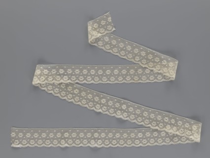 Lace fragment tied in the form of a belt with one-sided arched serrations. Regular ornament of