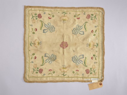 Napkin of white silk fabric embroidered with a pattern of single projections of large flowers and