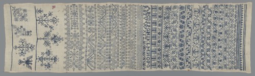 Embroidery sampler, Sampler with a cross-stitch pattern of trails, flower bushes, and letters. Blue