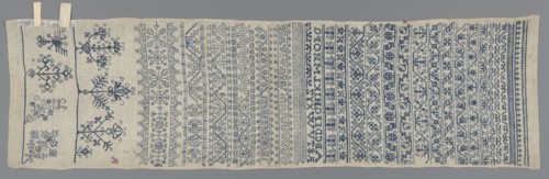 Embroidery sampler, Sampler with a cross-stitch pattern of trails, flower bushes, and letters. Blue