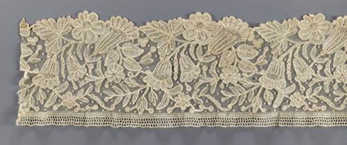 Lace fragment, bobbin lace with relief edges made with a needle on a tulle background, featuring a