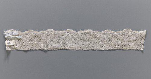 Lace fragment, bobbin lace, white, with a floral tendril ornament on a point de neige background,