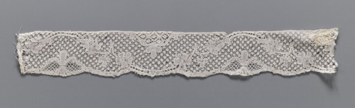 Lace fragment, mid-18th century. Binche lace, width 3.8 cm, length 30.5 cm. A tendril motif at the