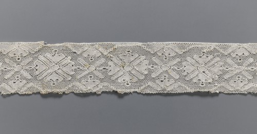 Lace fragment, bobbin lace with rosette ornaments framed by a tendril motif at top and bottom; mesh