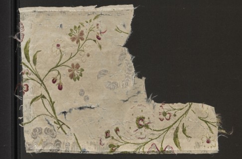 Fragment of white silk grosgrain brocaded with colorful threads and silver stitching; brocade