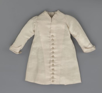 Children's dress made of cream satin. Long, fitted at the top, slightly flared at the bottom.