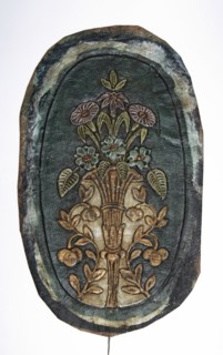 Fragment of a cordovan armrest, cordovan leather, flowers, flower bouquets, furniture upholstery.