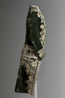Green velvet tailcoat, embroidered with motifs of field and garden flowers — roses, cornflowers,