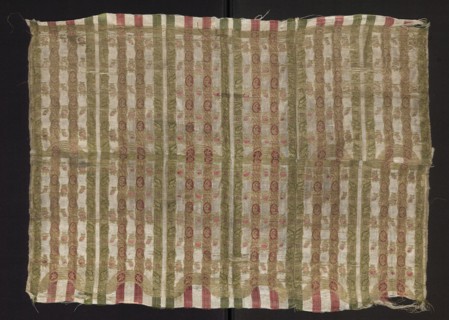 Fragment of silk fabric with fine stripes and a stylized plant ornament. Predominant colors: