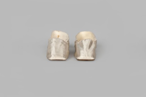 Women's slippers made of white silk with symmetrical thin leather soles and straight-cut toes.