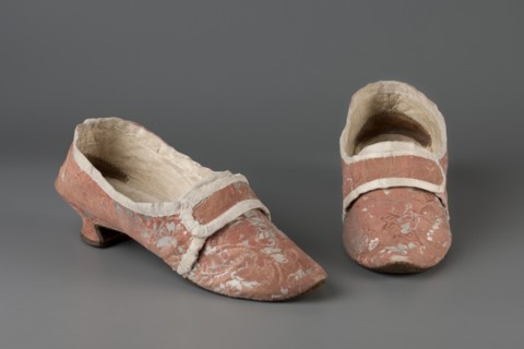 A pair of women's slippers made of patterned silk damask lined with leather. Dark pink outer fabric