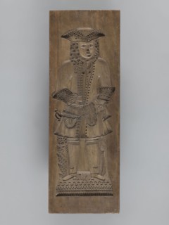 Double-sided gingerbread mould. Side A: image of a bachelor; Side B: baby in swaddling clothes.,