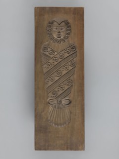Double-sided gingerbread mould. Side A: image of a bachelor; Side B: baby in swaddling clothes.,