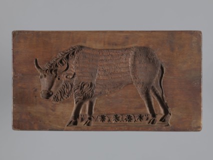 Double-sided gingerbread mould. Side A: bison; Side B: three representations — a bachelor in early
