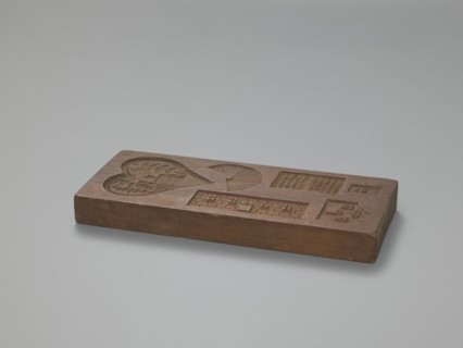 Double-sided gingerbread mould. Obverse: three hearts formed from laurel leaves, each containing
