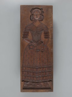 Double-sided gingerbread mould. Side A: female figure in a decorative bonnet and long patterned