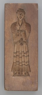 Double-sided gingerbread mould. Side A: female figure in a decorative, pleated early 19th-century