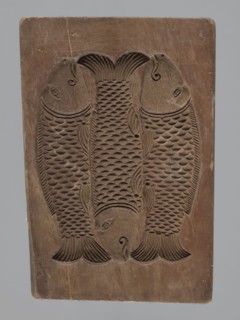 Double-sided gingerbread mould. Obverse: group of musicians; reverse: three fish. Double-sided,