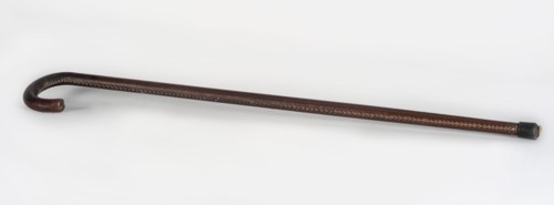 Walking stick, maker, wooden walking stick covered with brown leather along its entire length,