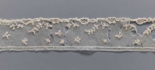 Fragment of needle lace of the point d'Alençon type. Cream needle lace with a mesh background of