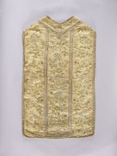 Chasuble, liturgical vestment. White chasuble covered with colorful and silver embroidery in a