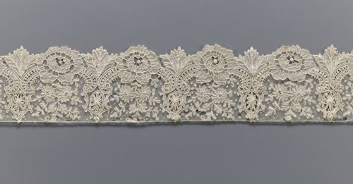 Lace fragment, purchase provenance noted; lace with plant ornaments. Serrated on one side, with a
