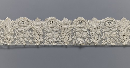 Lace fragment, lace with plant ornaments. Serrated on one side, with a pattern of flowers,