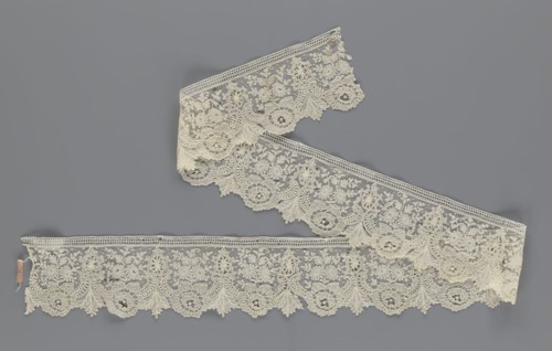 Lace fragment, lace with plant ornaments. Serrated on one side, with a pattern of flowers,