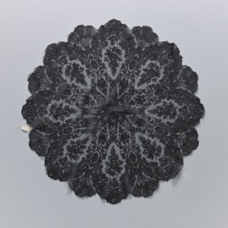 A fragment of lace umbrella cover, lace; patterns arranged radially from a central rosette; outer